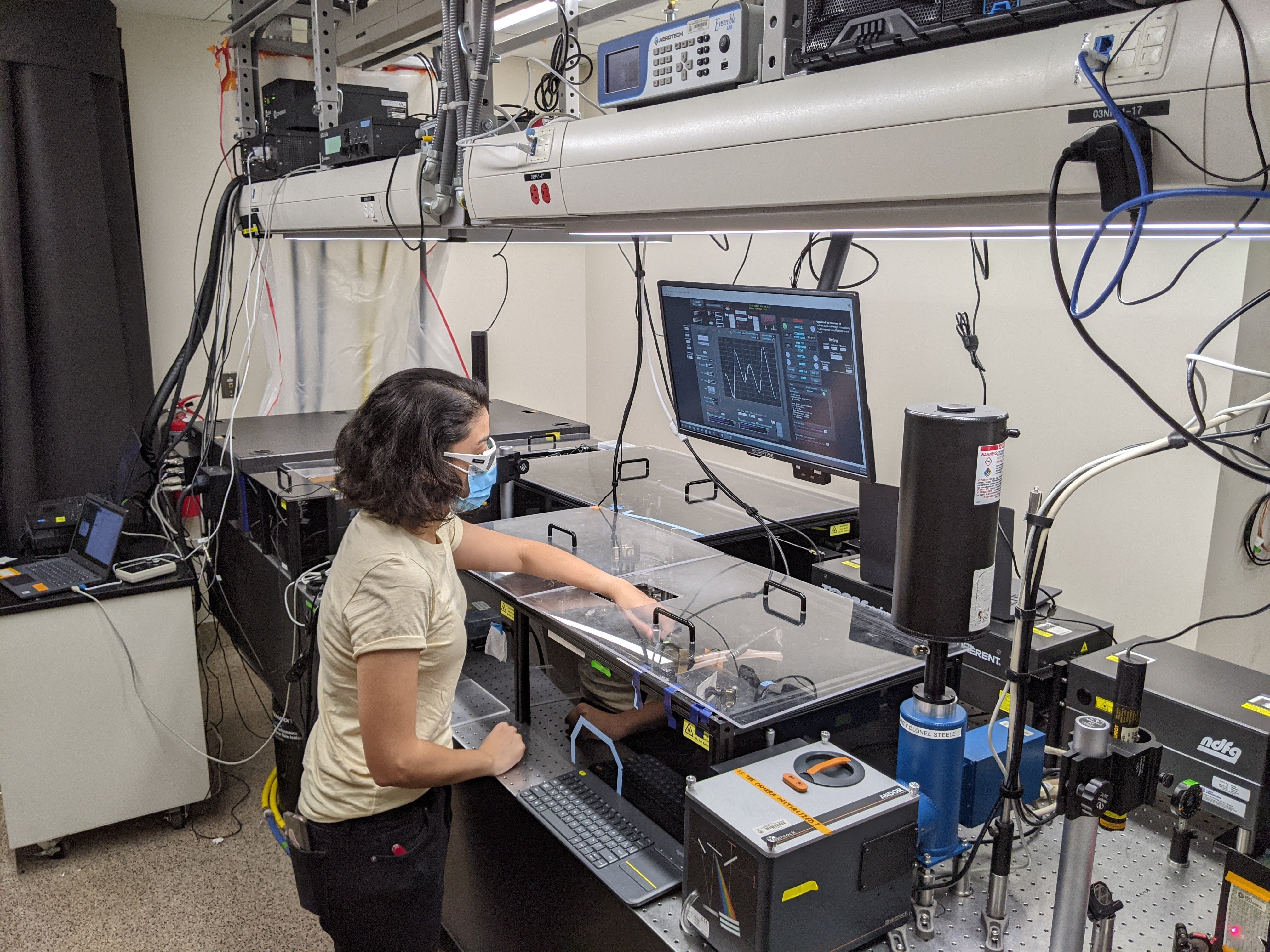 Ziareena Al Mualem, a graduate student at the time of the study,  measures samples on a two-dimensional infrared (2D IR) spectroscopy, an advanced laser-based technique that can map how molecules and surrounding water molecules interact on extremely fast timescales. Credit: Carlos Baiz / UT Austin