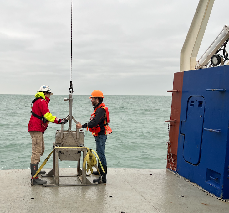 Researchers prepare the box corer to be lifted down into the water. 